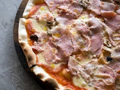 Pizza regina, pizza con funghi e prosciutto cotto e mozzarella di bufala : pizza with mushroom, cooked ham, and buffalo mozzarella, at an Italian restaurant…