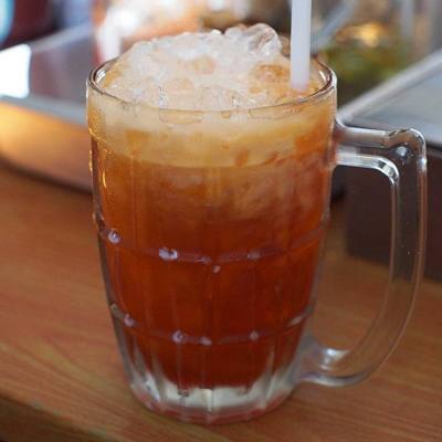 Cha yen (Thai script: ชาเย็น, lit. "cold tea") as served at a noodle shop in Chiang Mai. The tea is spiced and mixed with sweetened, condensed milk.