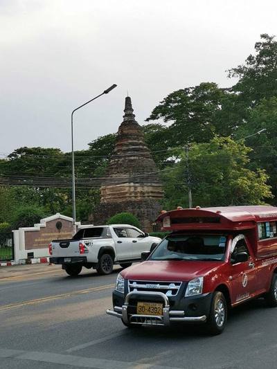Chiang Mai portrayed by its famous red Songthaew and its historic site.