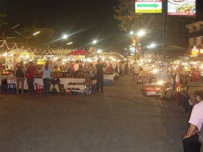 An open-air section of the Chiang Mai night bazaar, in a town square.