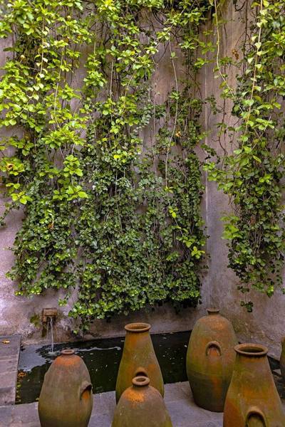 Earthen jugs next to a small fountain outside the Luis Barragàn House and Studio , Mexico City