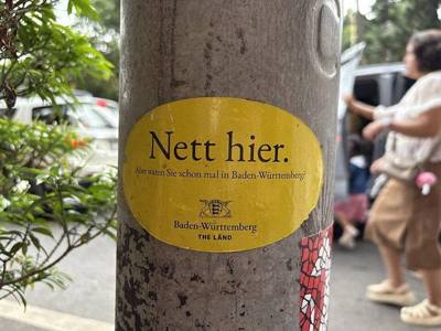 A German 'Nett Hier' sticker on a electricity pole in front of Wat Phra That Doi Suthep Temple, Chiang Mai, Thailand