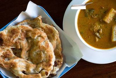 Thai-Muslim roti with beef curry in the city of Chiang Rai. After frying, the roti was fluffed by clapping it in between two hands while wrapped in a cloth.…