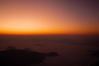 A breathtaking view of the sea of mist blanketing the valleys at Phu Chi Fa during a vibrant sunrise.