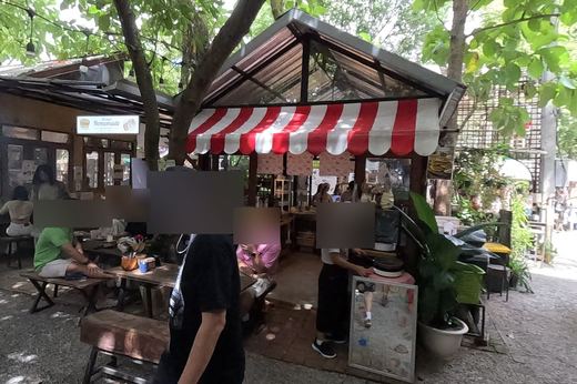 Red-and-white awning snack stall and bakery tables — Chamcha Market, San Kamphaeng