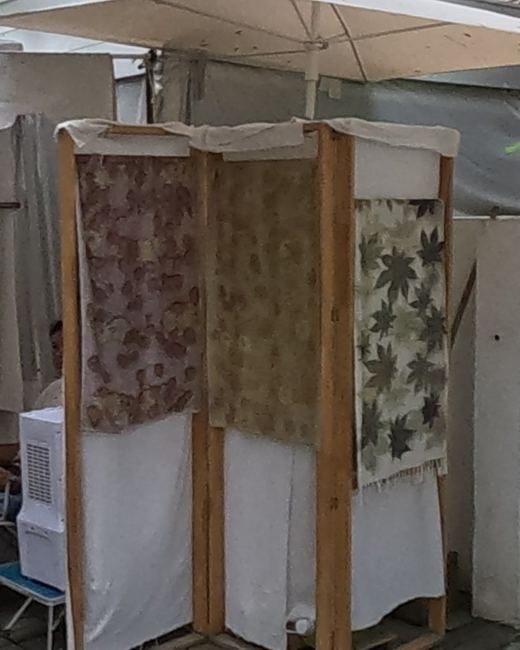 Leaf-printed scarves on a wooden rack — Chamcha Market, San Kamphaeng