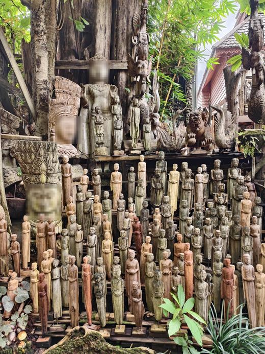 Shelves of slender carved figures, a crowned head at the end