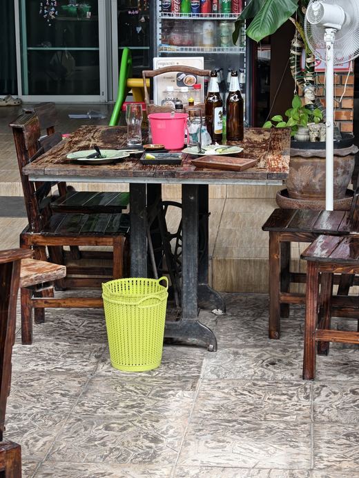 Rock Star Cafe's terrace: old wooden tables, a fan, drinks on a shelf