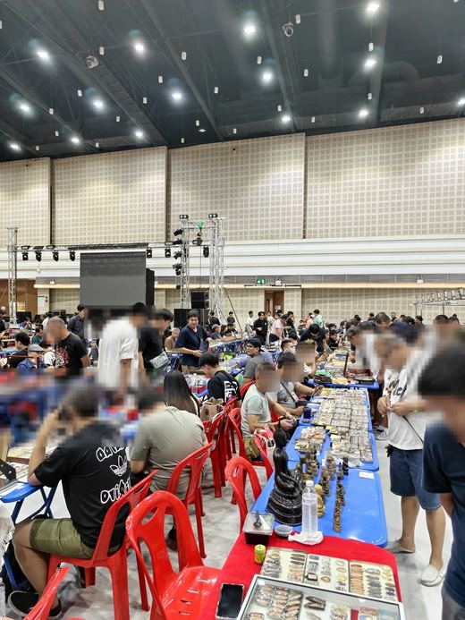 The amulet contest at Chiang Mai Hall: rows of dealers' tables under the lights