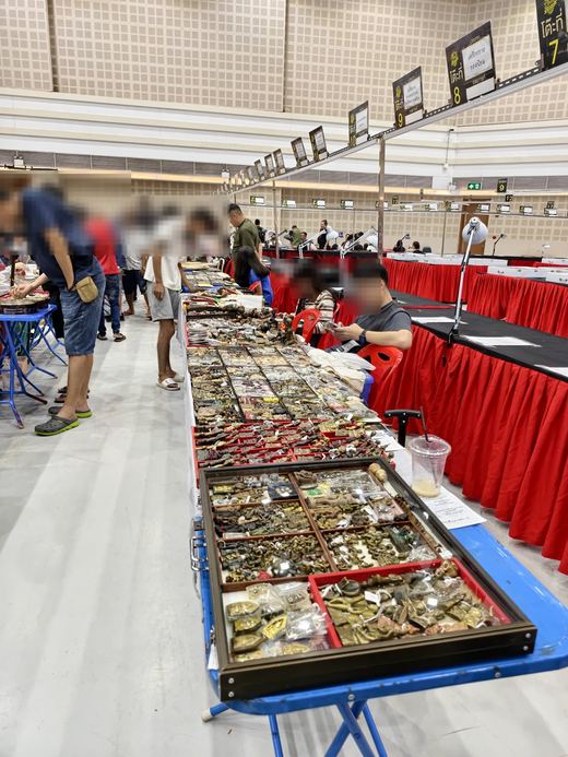 Amulet trays along red-skirted tables at the Chiang Mai Hall contest