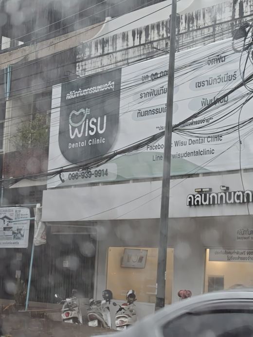 WISU Dental Clinic's front in the rain, seen through a car window