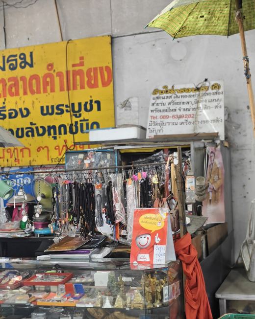 A framing stall under the Kamthieng club's yellow sign: chains, cords and cases