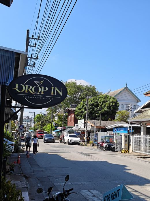 Drop In's oval sign over the lane, Restaurants and Bar, the street running on to Batman Tours