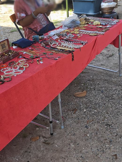 Beaded bracelets and necklaces along a red-clothed table