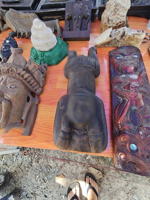 Carved wooden masks and a hardwood face panel on an orange tabletop