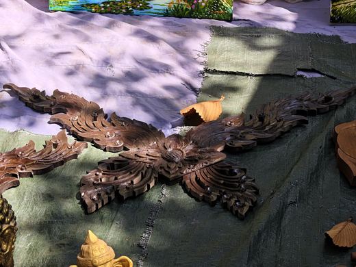 A carved wooden ceiling rosette on a tarp