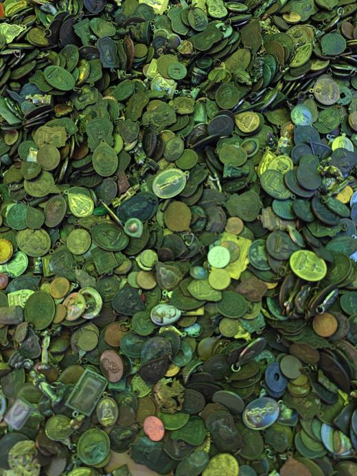 A heap of old coins and medallions, green with age