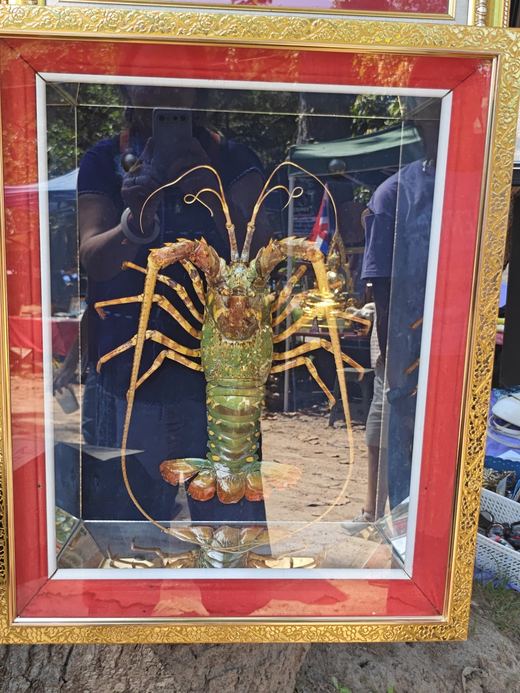 A gilded lobster framed in red and gold