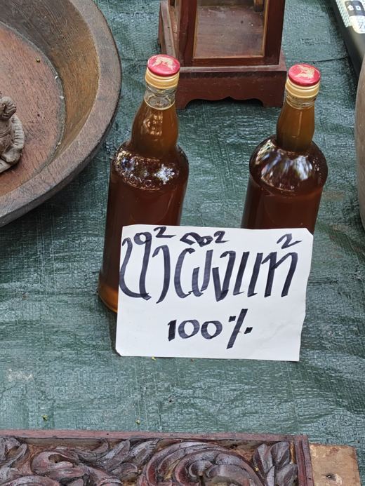 Two bottles of honey with a handwritten card: น้ำผึ้งแท้ 100%