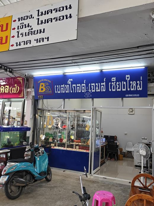 Best Gold Gems' shop: a plating sign for gold, silver, rhodium and nak, a blue scooter out front