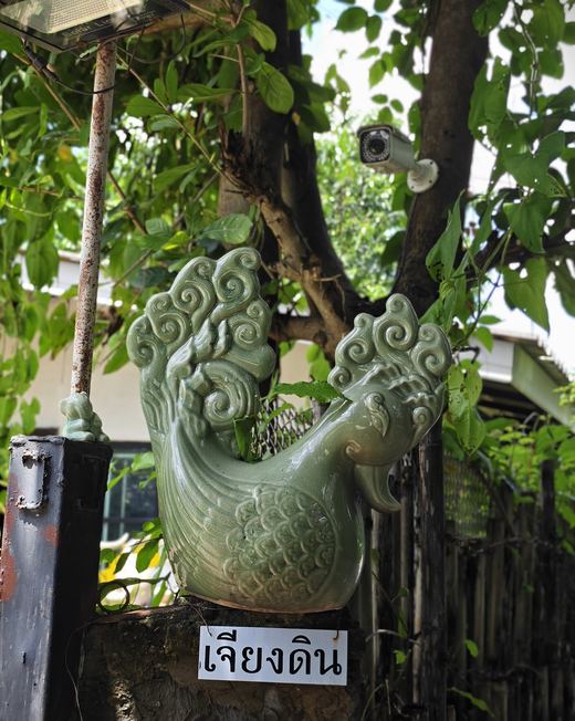 Chiang Din's sign under a green ceramic phoenix