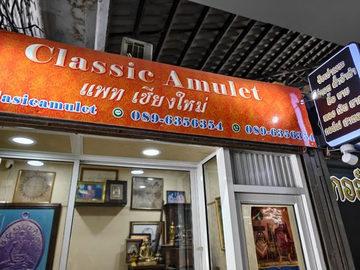 Classic Amulet's orange sign over a shop of framed amulets