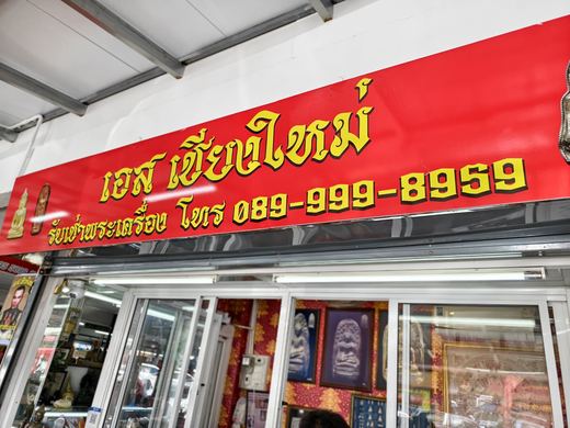 S Chiang Mai's red sign over a shop of framed amulets