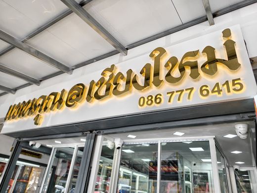 Tankhun@Chiang Mai's lit gold lettering over glass cases