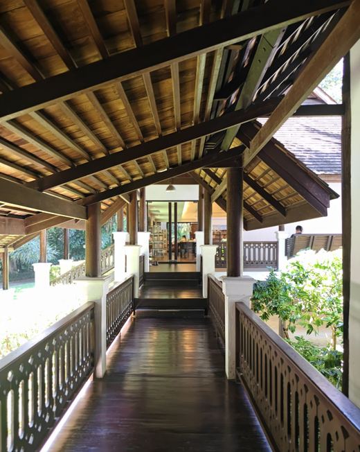 A covered teak walkway leading to the EFEO library