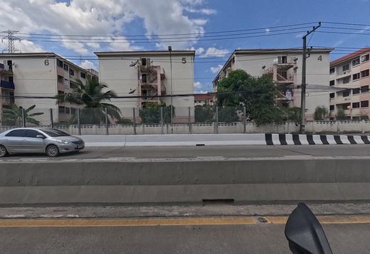 Across the median, Baan Ua Arthorn blocks 6, 5 and 4 stand behind a wall and clear noise panels.