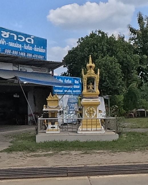 Gold spirit houses in front of พี เอ ซาวด์ car-audio shop