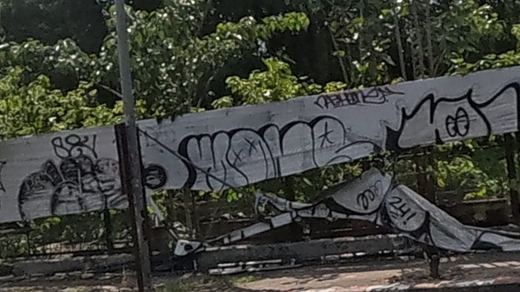 Spray tags along a roadside fence