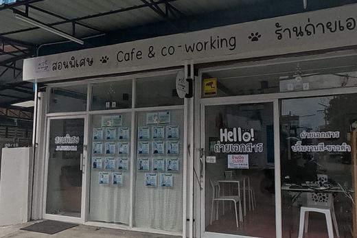 A shopfront combines a tutoring/cafe-and-coworking space (posters for 'JA WISDOM' classes in the window) with a photocopy shop next door advertising colour and