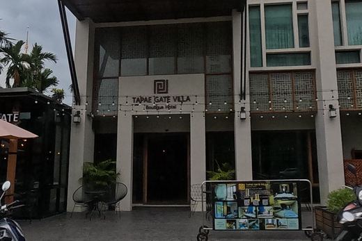 A boutique hotel and its streetside cafe stand at the corner, scooters parked out front.
