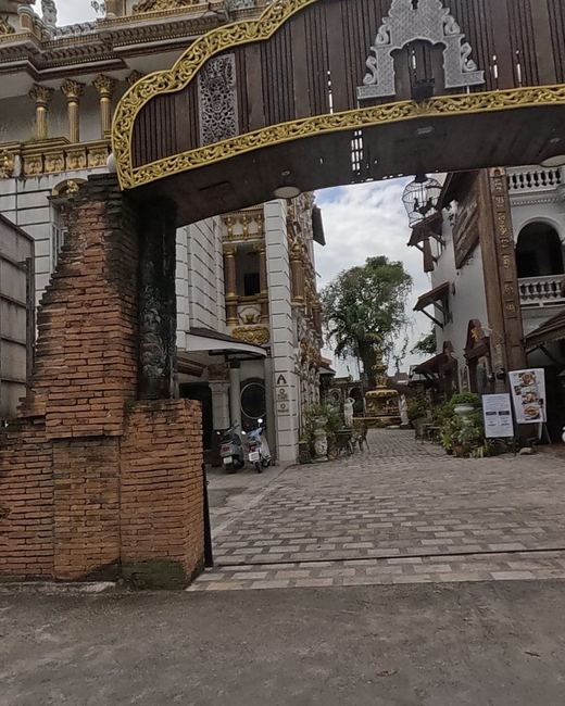 Gold-trimmed brick gateway into an opulent courtyard