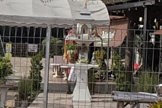 White statue on a pedestal at a garden restaurant entrance