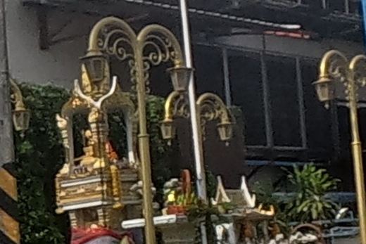 Gold shrine with a small elephant figure at a roadside property
