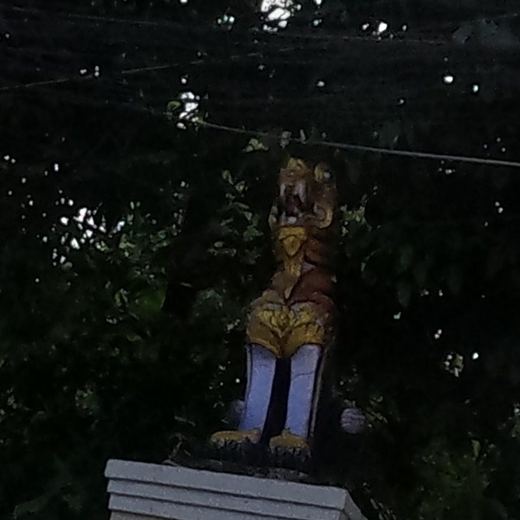 Gilded guardian statue on the temple wall