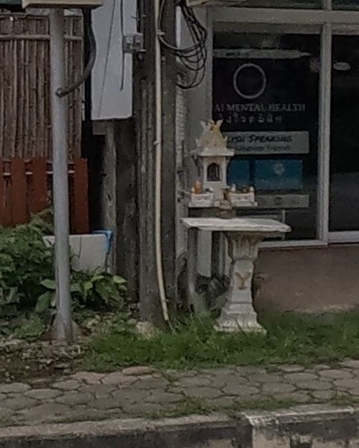 A small white shrine by a clinic entrance