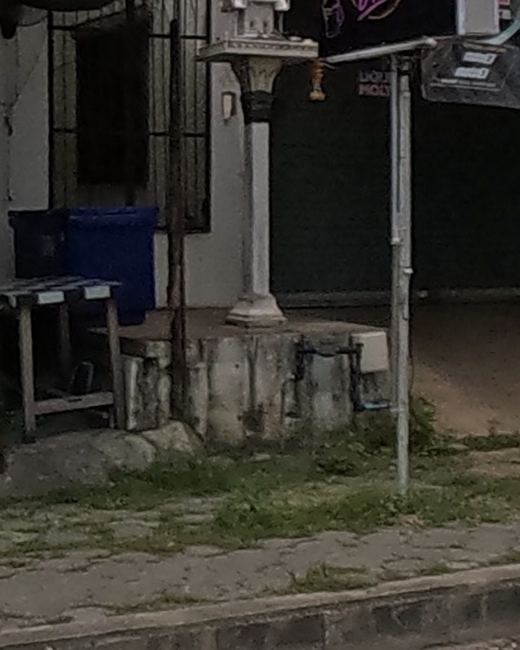 A small white shrine by a restaurant's outdoor seating