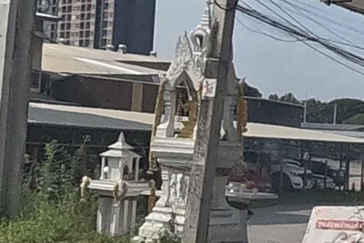 Spirit house beside an auto parts shop