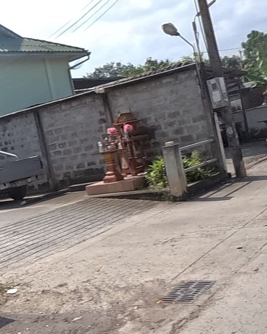 Two spirit houses at a gate
