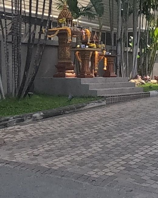 Garlanded spirit houses at a hotel entrance