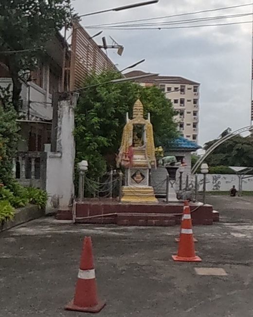 Gold spirit house at a temple compound entrance