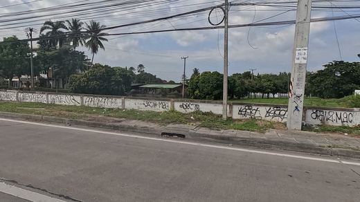 long wall covered in black spray tags