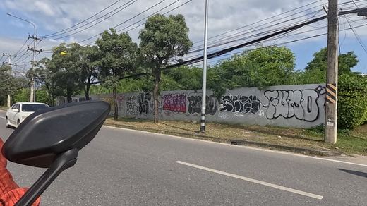 long tagged boundary wall reading FURO