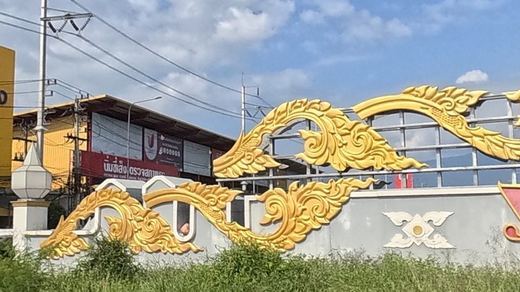 gilded Lanna-style relief ornament on a roundabout wall