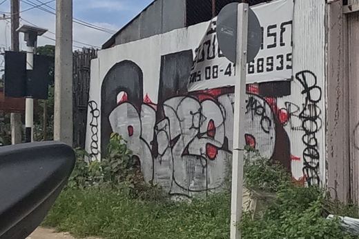 Black tag cluster with a heart on a derelict shophouse wall