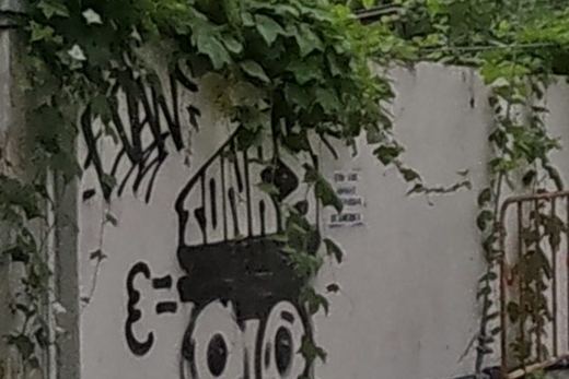 Stencil-style robot/tank character with gear wheels on a white wall