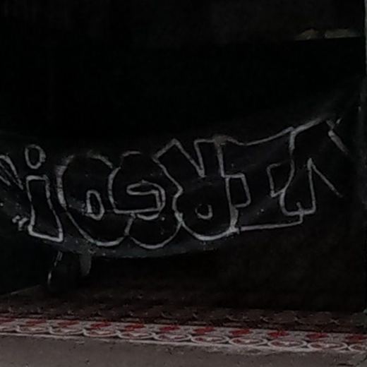 White-outline bubble tag on dark shopfront shutter